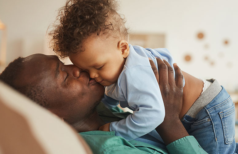 Father kissing small child